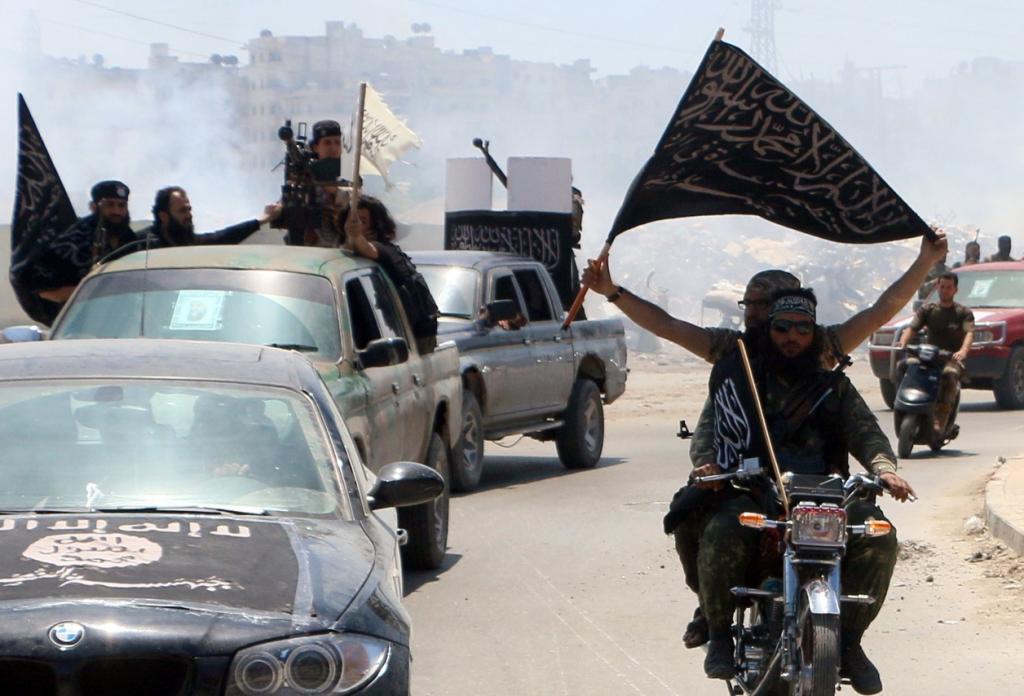 Fighters from Al Qaeda's Syrian affiliate Al-Nusra Front in the northern Syrian city of Aleppo flying Islamist flags as they head to a frontline on May 26, 2015. (AFP/Getty Images)