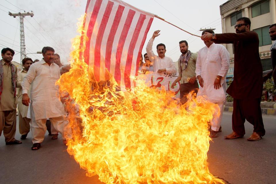 A Pakistani demonstrator holds a burning US flag as others shout slogans during a protest in Multan on May 24, 2016, against a US drone strike in Pakistan's southwestern province Balochistan. - SS MIRZA/AFP/GETTY IMAGES