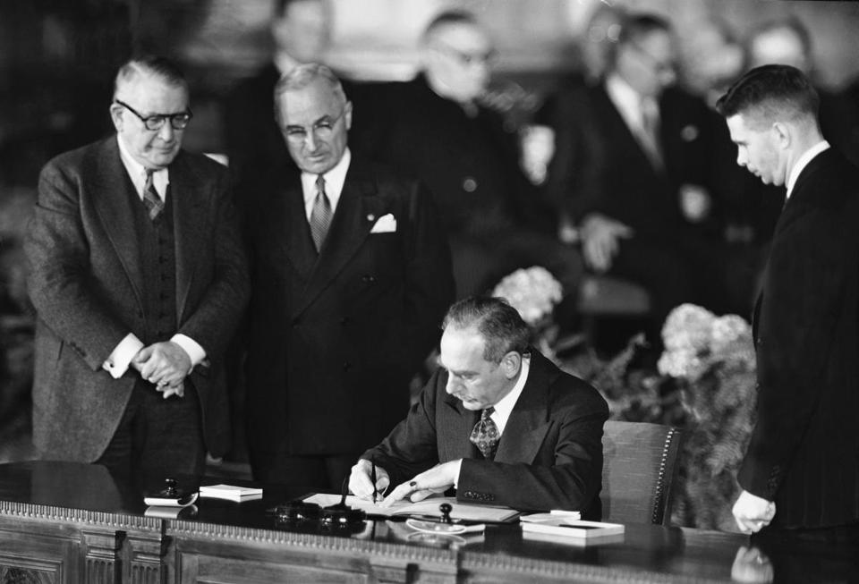 Secretary of State Dean Acheson signed the Atlantic defense treaty for the United States on April 4, 1949 while President Harry Truman looked on. - ASSOCIATED PRESS
