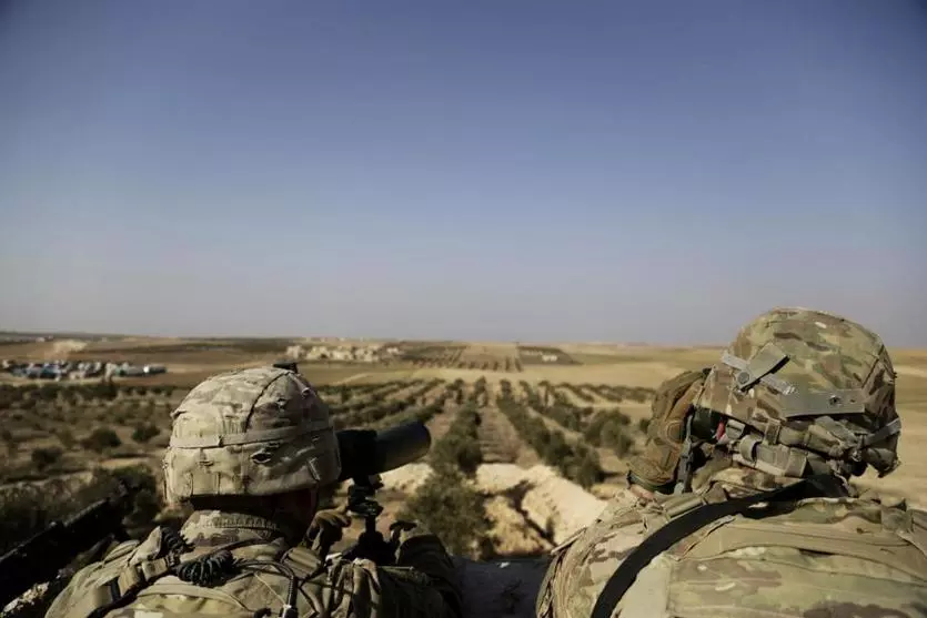 American troops look toward the border with Turkey from a small outpost in northern Syria in February. - AP PHOTO/SUSANNAH GEORGE