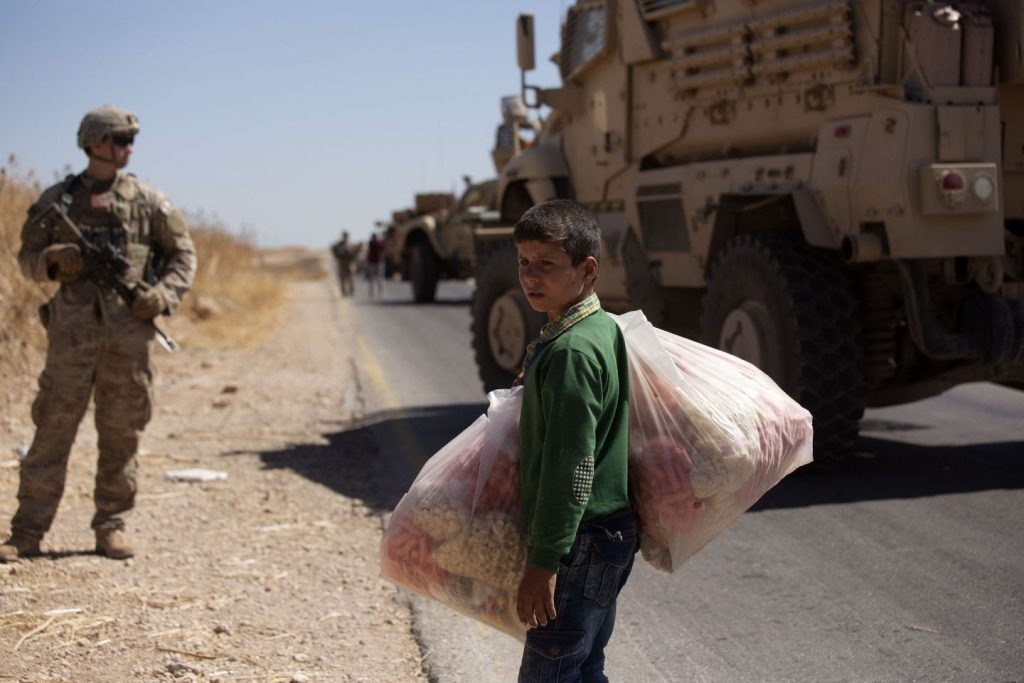In September, a US soldier on a road in Syria as a boy carried snacks to sell in the so-called safe zone on the Syrian side of the border with Turkey. MAYA ALLERUZZO/AP