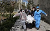 People wearing protective clothing carry the body of a victim who died after being infected with the new coronavirus at a cemetery just outside Tehran, Iran.EBRAHIM NOROOZI/ASSOCIATED PRESS